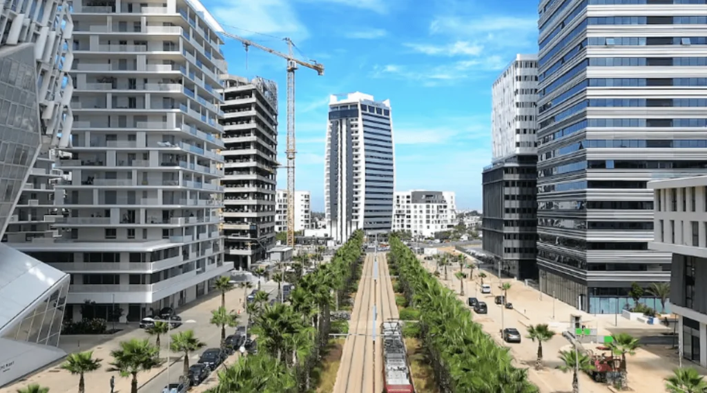 Vue aérienne d'une avenue moderne avec tramway et immeubles neufs.
