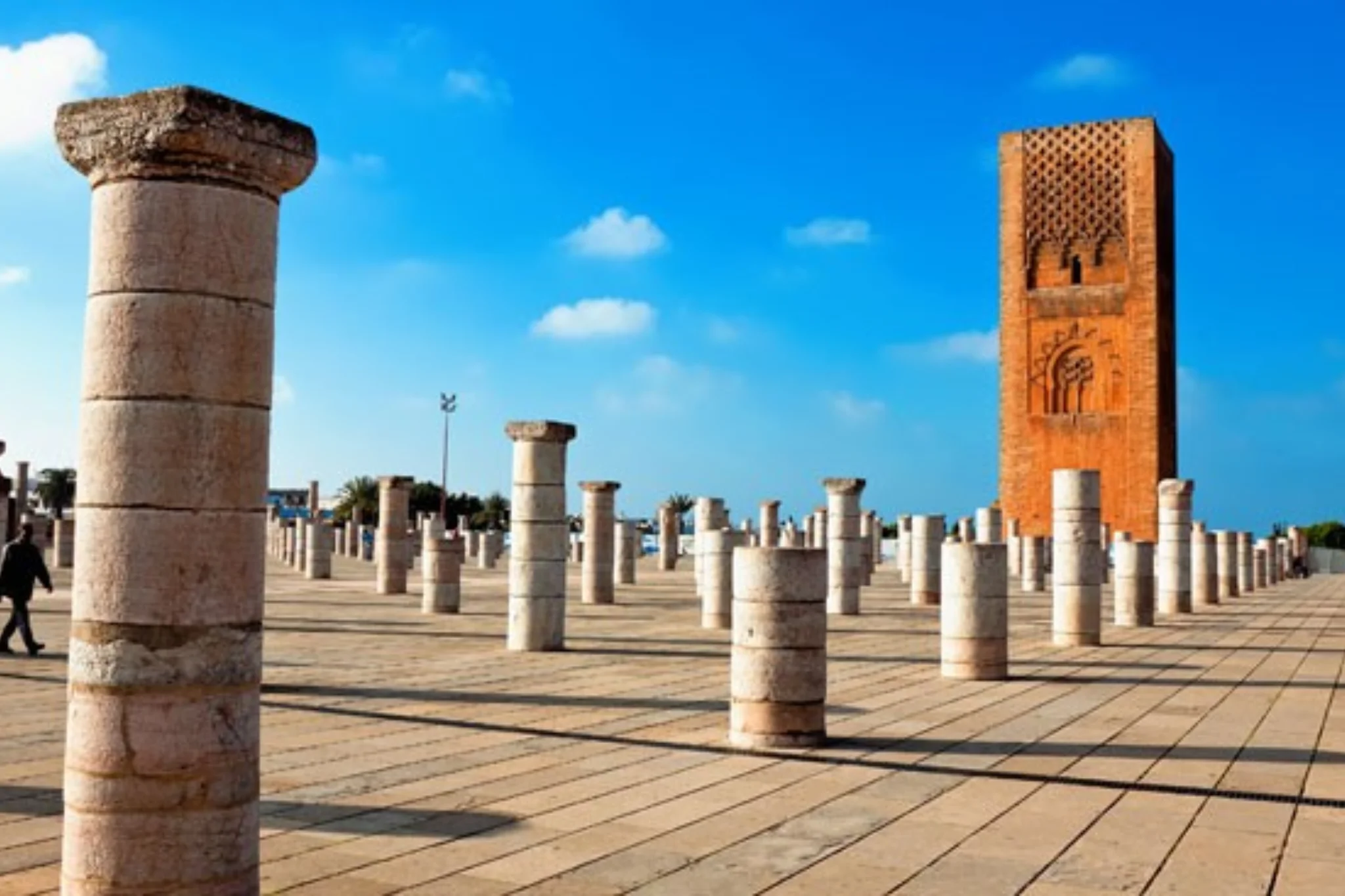 Historiques colonnes de pierre devant la tour Hassan sous un ciel bleu.