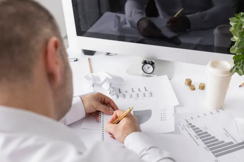 Homme d'affaires analysant des graphiques financiers à son bureau