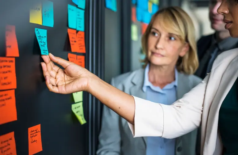 Collaborateurs organisant leurs tâches avec des notes repositionnables