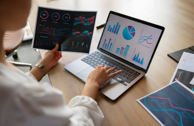 Analyste travaillant sur des graphiques et données sur son ordinateur